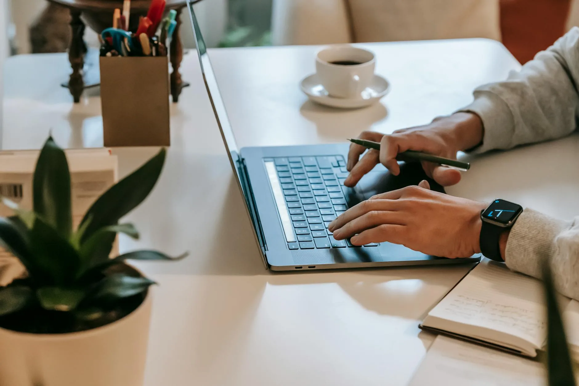 Trabajador por cuenta propia revisando sus finanzas en una laptop con papeles sobre el escritorio