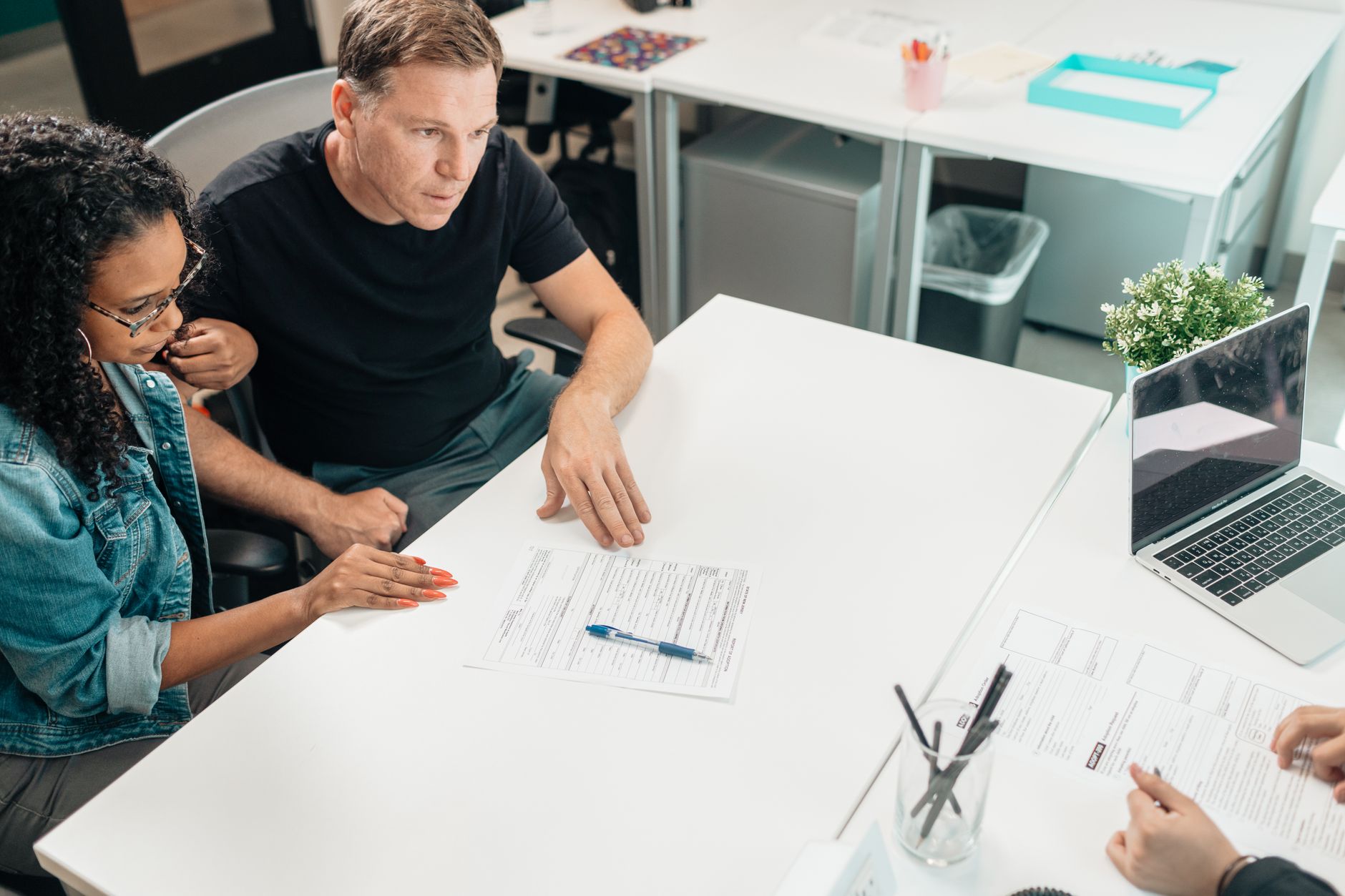 A couple reviewing a life insurance policy with an advisor at a desk
