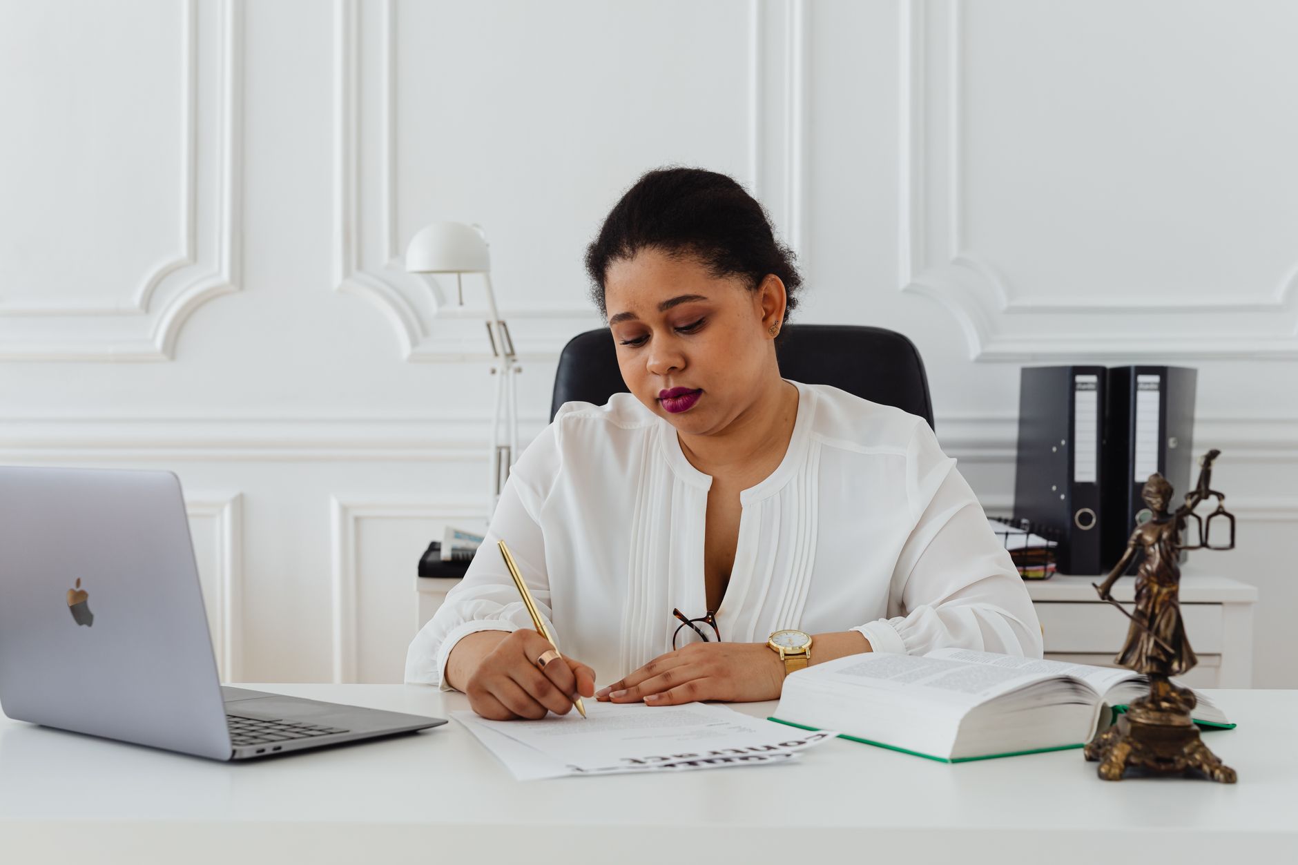 A client signing a document with a notary across a desk