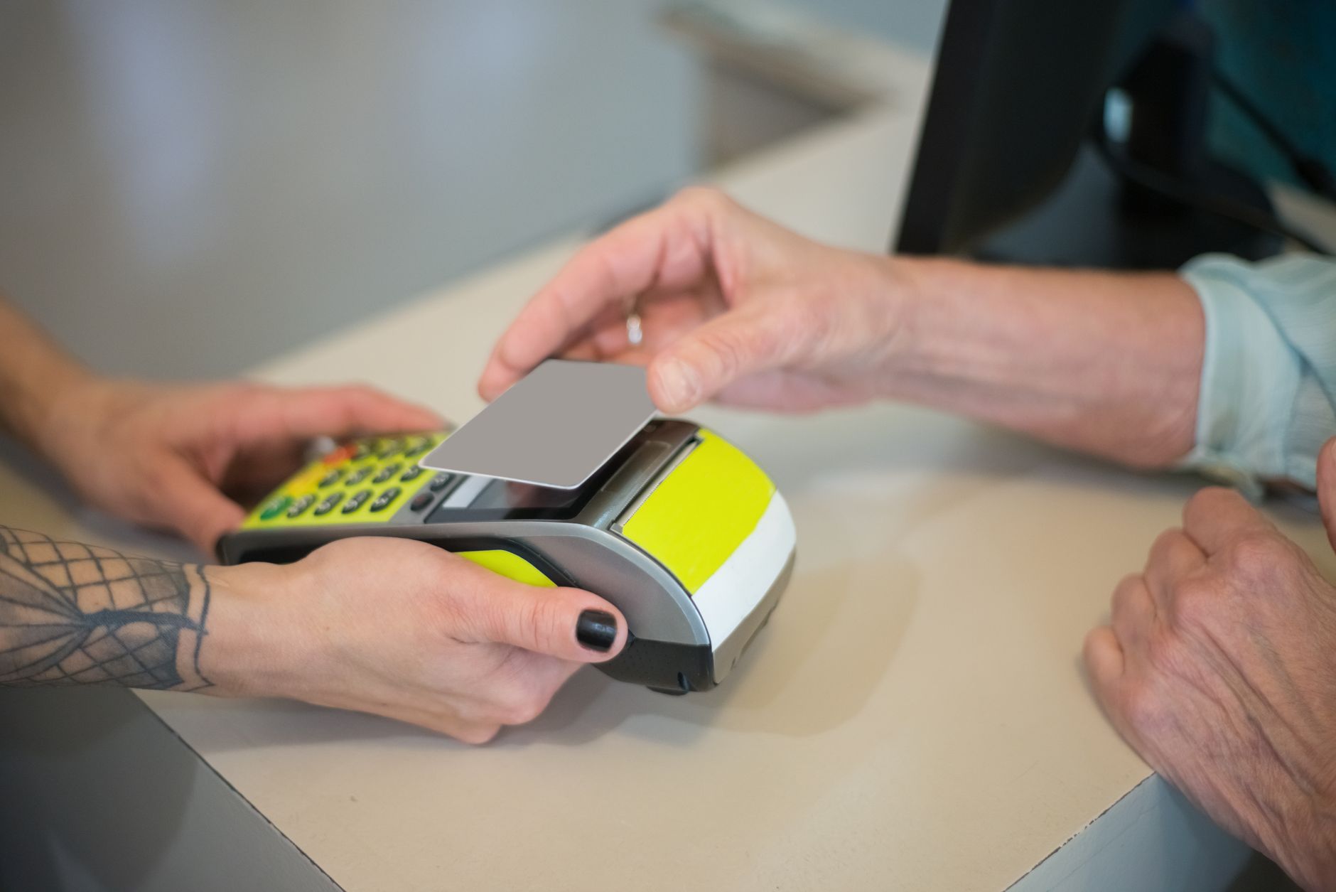 An older adult paying at a pharmacy checkout