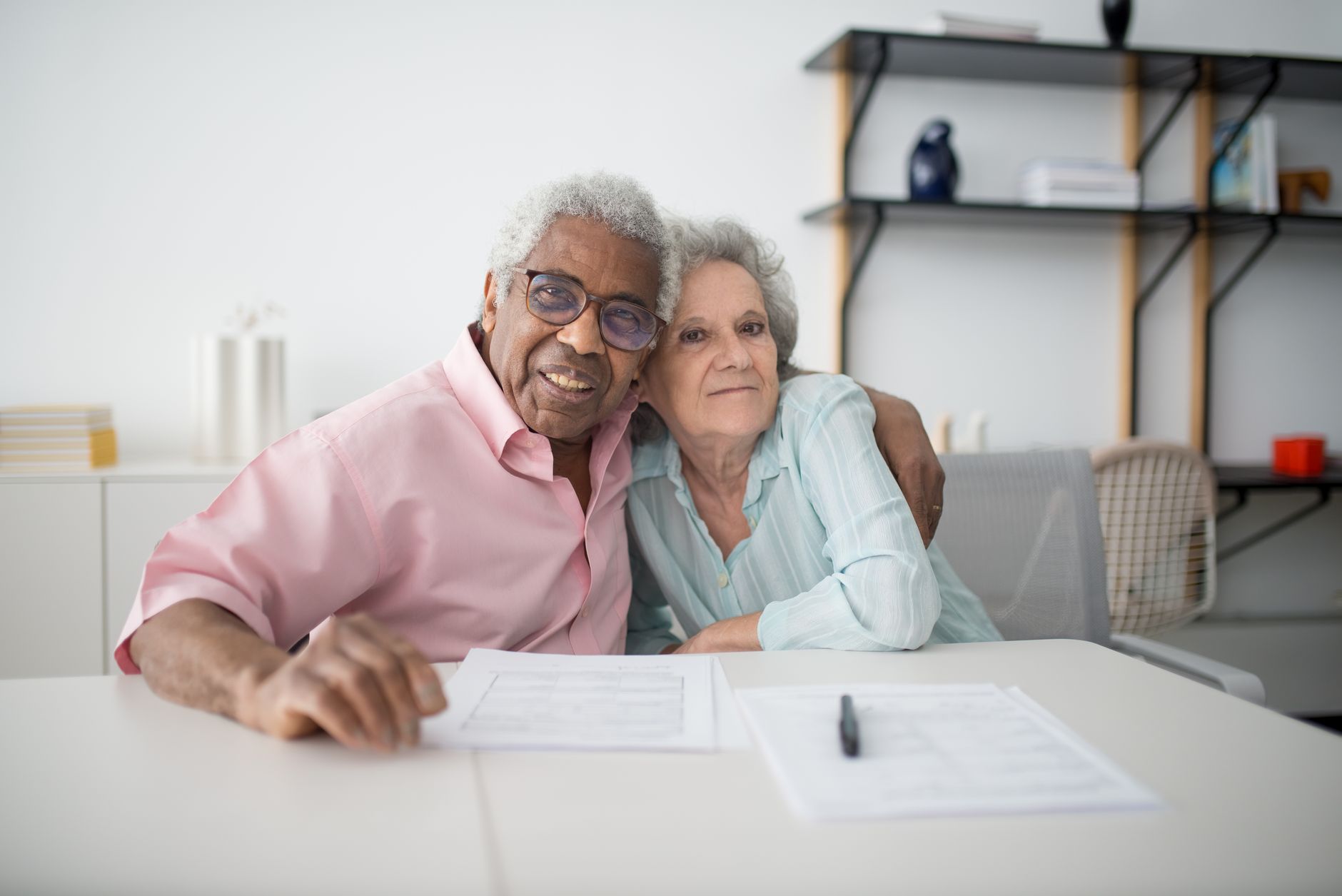 An older couple reviewing paperwork together at their kitchen table