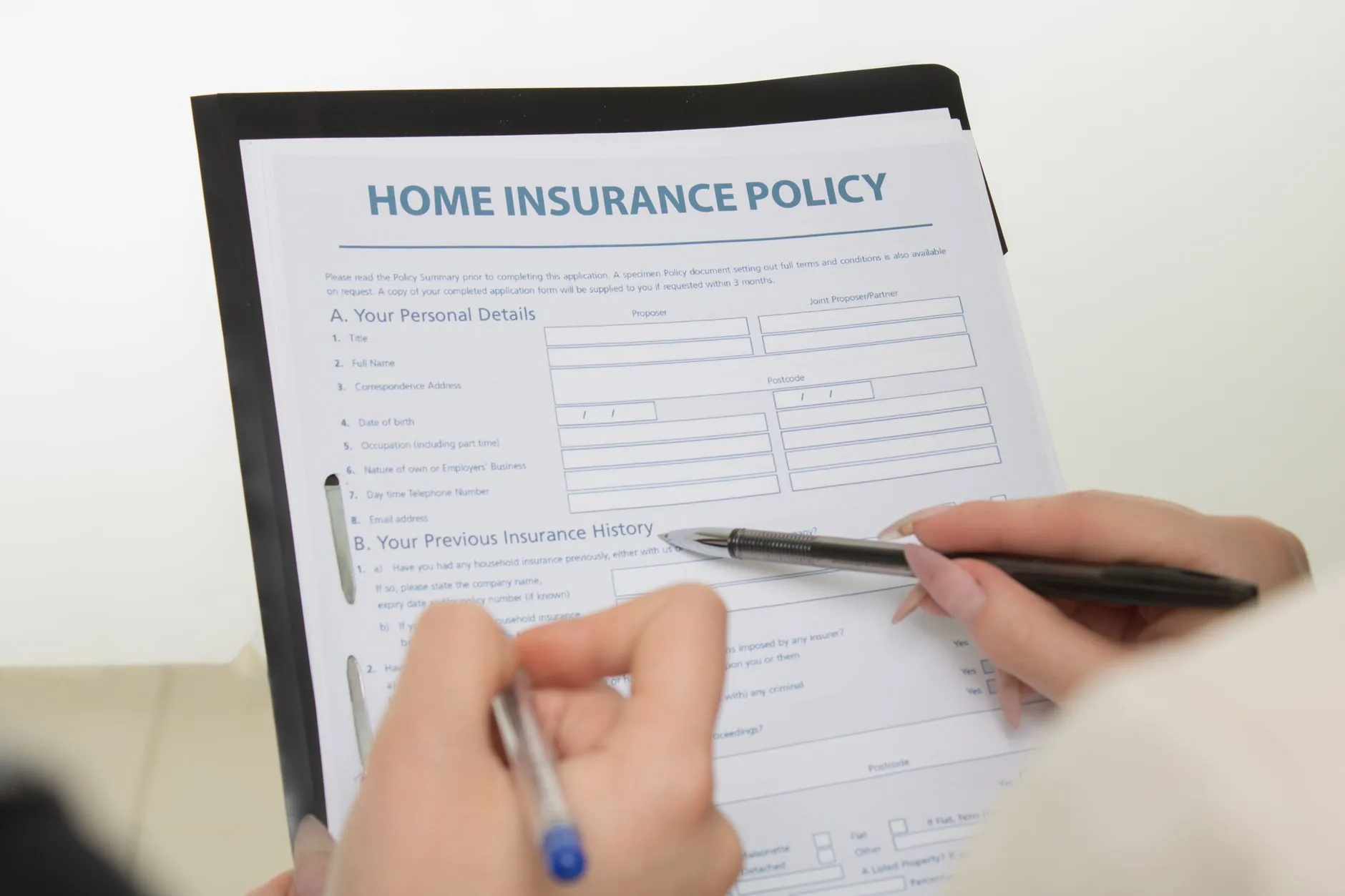 A home insurance policy document and a pen on a desk